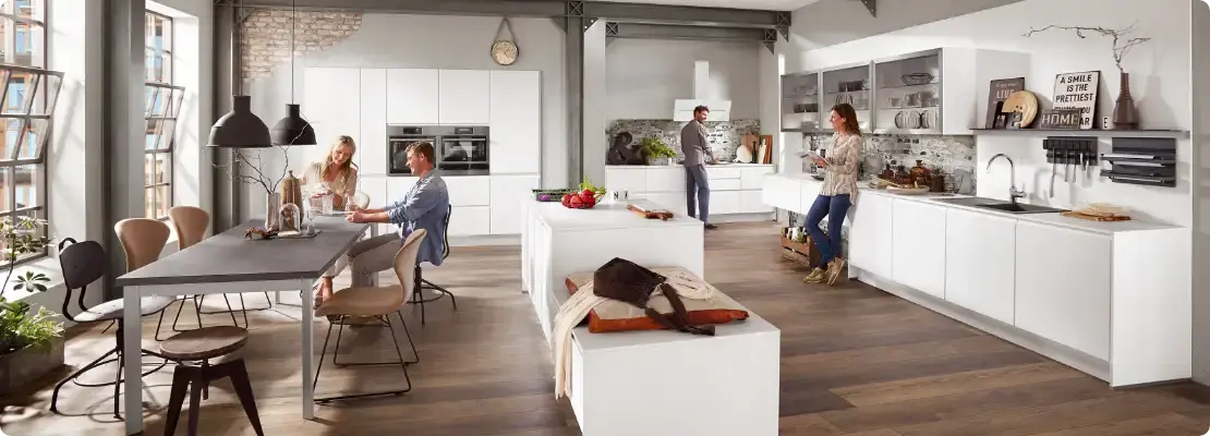 people in kitchen dining space white cupboards